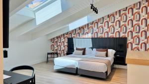 a bedroom with a large bed with a red and white wall at Soho Boutique La Harinera in Valladolid