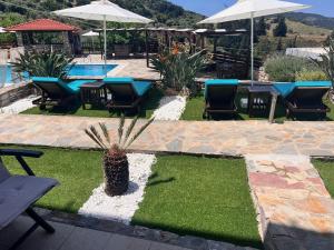 a patio with tables and chairs and a pool at Ataviros Hotel in Émbonas