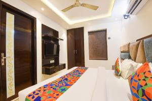 a hotel room with a bed and a television at FabHotel Dev Palace II - Nr Ashok Vihar in New Delhi +23 photos