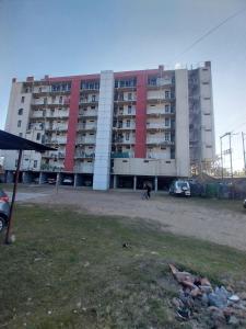 a large building with a parking lot in front of it at Backpackers Hub in Dimapur
