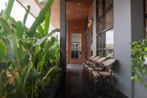 a row of chairs in a hallway with plants at Mastiff Hotel Hinjawadi Pune in Pune