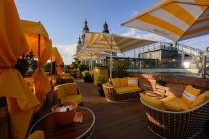 a patio with chairs and tables and umbrellas at Aria Hotel Budapest by Library Hotel Collection in Budapest