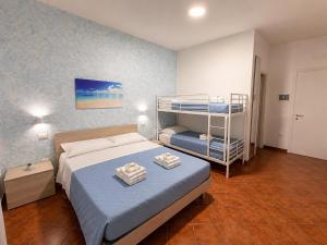 a bedroom with a bed and a bunk bed at Donna Ginevra Rooms - A soli 300m dalla Spiaggia in Lido Marini
