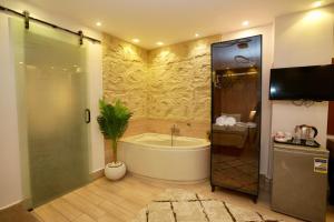 a bathroom with a tub and a shower with a plant at Royal Plaza Pyramids View in Cairo +110 photos