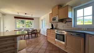 a kitchen with wooden cabinets and a table in it at Panorama Haus am Traunsee in Traunkirchen