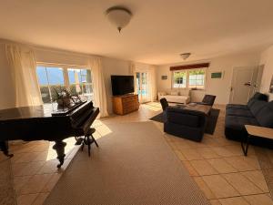 a living room with a piano and a couch at Panorama Haus am Traunsee in Traunkirchen