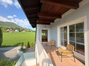 a porch of a house with two chairs and a window at Panorama Haus am Traunsee in Traunkirchen