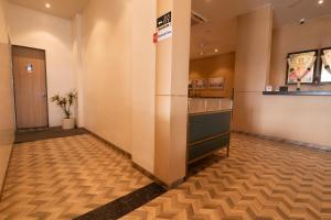 an empty lobby with a waiting room with a reception desk at Mastiff Hotel Hinjawadi Pune in Pune