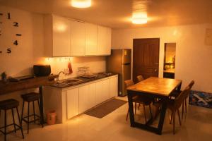 a kitchen with a wooden table and a kitchen with a table and chairs at Mayumi Lodge in Puerto Princesa City