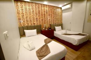 a hotel room with two beds and a wall at Royal Plaza Pyramids View in Cairo