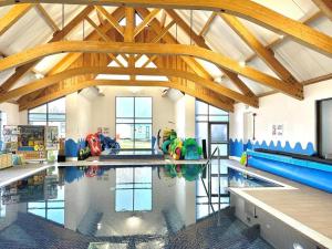 a large swimming pool with wooden beams in a building at Sunset Seeker Morecambe in Morecambe