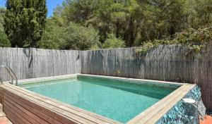 a swimming pool in front of a wooden fence at Begur "Casa es Pou" in Begur +1 photo