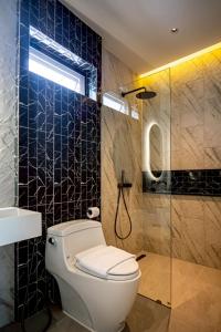 a bathroom with a toilet and a glass shower at Triple P พูลวิลล่า ชะอำ in Ban Bo Prakhon