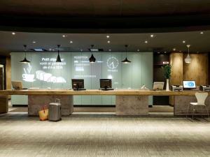 eine Lobby mit einem großen Schreibtisch, auf dem Computer stehen in der Unterkunft ibis Berlin City Potsdamer Platz in Berlin