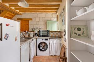 a kitchen with a washing machine and a refrigerator at Le Bourg Joly in Rigny-Ussé