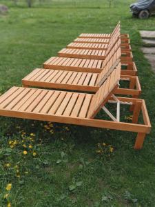 a wooden bench sitting on the grass in a park at Sadyba u Vani in Volovets