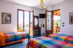 a living room with two beds and a balcony at Villa Artemis by Isula in Lipari