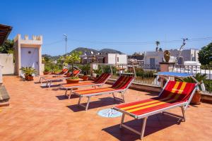 a row of lounge chairs sitting on a roof at Villa Artemis by Isula in Lipari