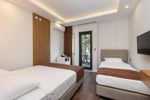two beds in a room with a tv at Royal Dream's Hotel in Kemer