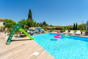 a swimming pool with a slide and a pool noodle in a backyard at Mas Delorme 2 in Arles
