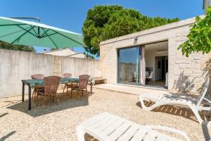 a patio with a table and chairs and an umbrella at Mas Delorme 2 in Arles