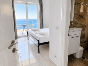 a bathroom with a bed and a view of the ocean at Palasa View in Dhërmi +28 photos