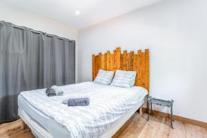 a bedroom with a large bed with a wooden headboard at Mas Delorme 2 in Arles +17 photos