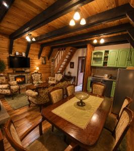 a living room with a table and a kitchen at White pine cottage in Motički Gaj