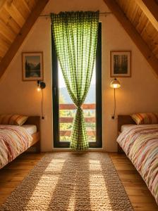 a bedroom with a window with a green curtain at White pine cottage in Motički Gaj