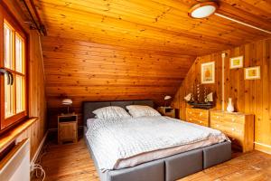 a bedroom with a bed in a wooden cabin at Leśny Raj in Świętajno
