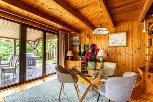 a dining room with a glass table and chairs at Leśny Raj in Świętajno +30 photos