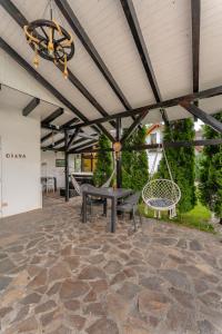 a patio with a bench and a table and a swing at Cabana Diana in Avrig