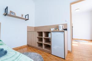 a small kitchen with a refrigerator and a shelf at Pensjonat Perła in Grzybowo