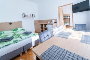 a room with two beds and a table and chairs at Pensjonat Perła in Grzybowo