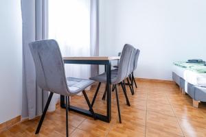 a dining room table with two chairs and a bed at Pensjonat Perła in Grzybowo