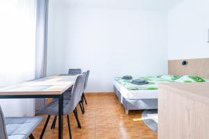a room with a bed and a table and chairs at Pensjonat Perła in Grzybowo +41 photos