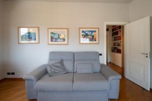 a blue couch in a living room with paintings on the wall at La Basilica in Verbania
