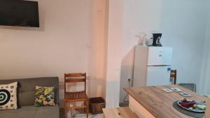 a living room with a table and a white refrigerator at MUSHROOMs1 AFYTOS in Afitos
