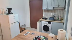 a small kitchen with a washing machine and a table at MUSHROOMs1 AFYTOS in Afitos +3 photos
