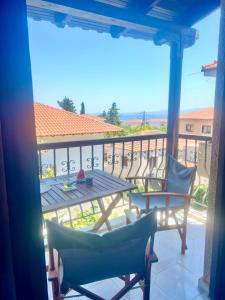 a table and chairs on a balcony with a view of the ocean at MUSHROOMs1 AFYTOS in Afitos