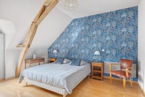 a bedroom with a bed and a blue wall at Le Bourg Joly in Rigny-Ussé