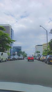 a street with cars parked on the side of the road at THE TIMES HOUSE, Toit panoramique vue mer & groupe électrogène in Libreville