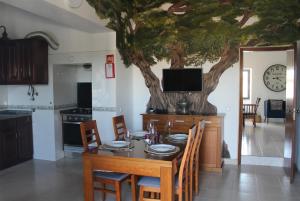 a dining room with a table with a tree on the wall at Campo Dias in Silves