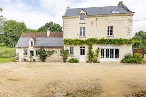 an exterior view of a large stone house at Le Bourg Joly in Rigny-Ussé