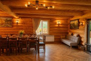 a dining room with a table and a couch at Derevo House in Yasinya