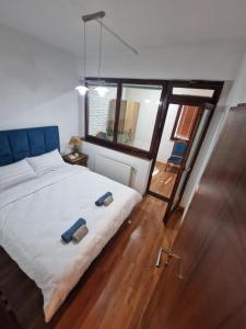 a bedroom with a large bed and a large window at Apartman BLUERESIDENCE Šamac in Bosanski Šamac
