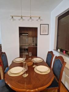 a dining room table with plates and wine glasses on it at Apartman BLUERESIDENCE Šamac in Bosanski Šamac