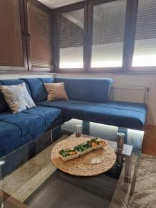 a blue couch in a living room with a table at Apartman BLUERESIDENCE Šamac in Bosanski Šamac