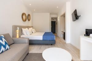 ein Hotelzimmer mit einem Bett und einer Couch in der Unterkunft Hotel Baltum in Albufeira