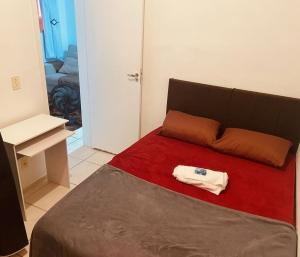a bedroom with a bed with a red blanket at Acalmaria Residence in Macaé +14 photos